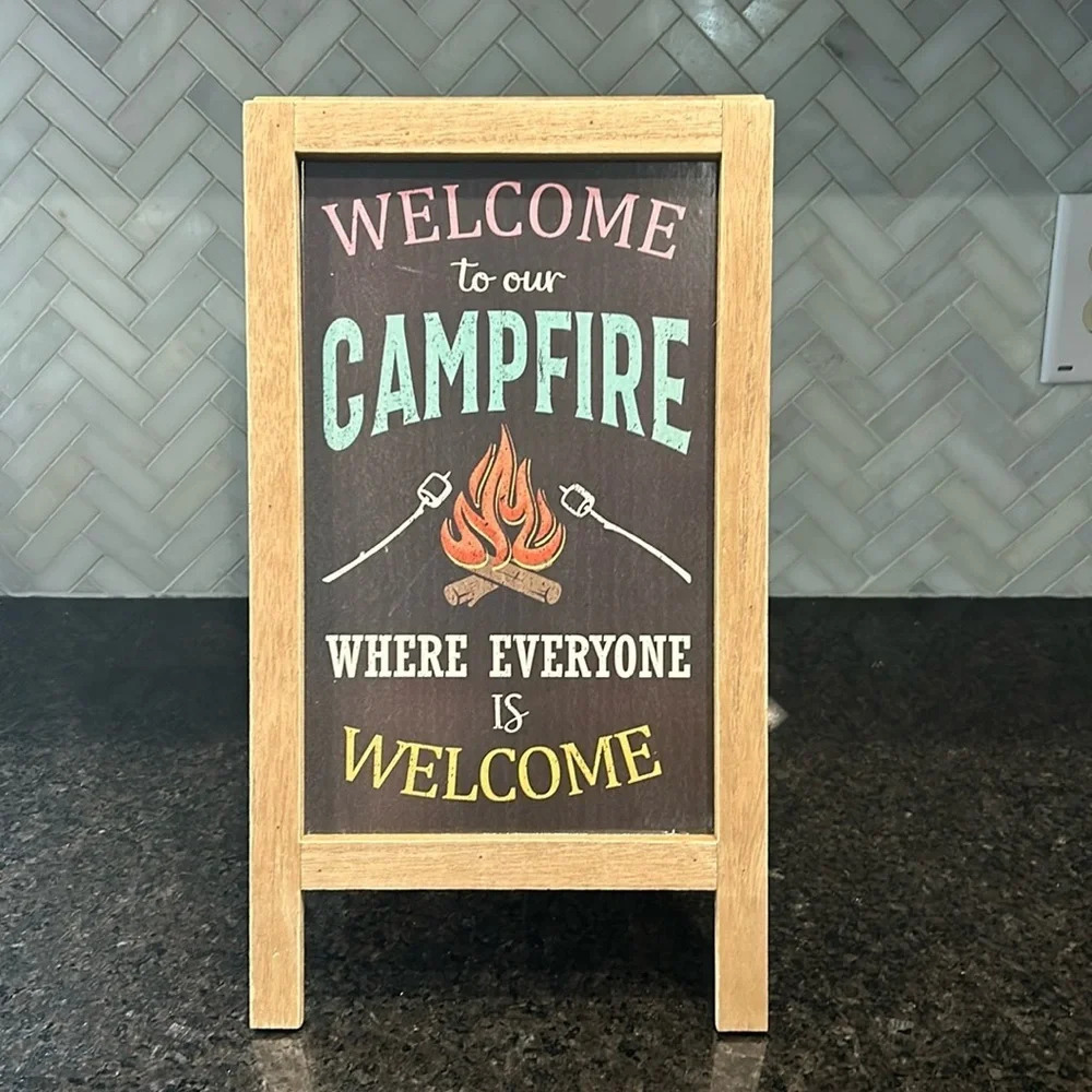 Welcome to our campfire where everyone is welcome wooden sign tan table